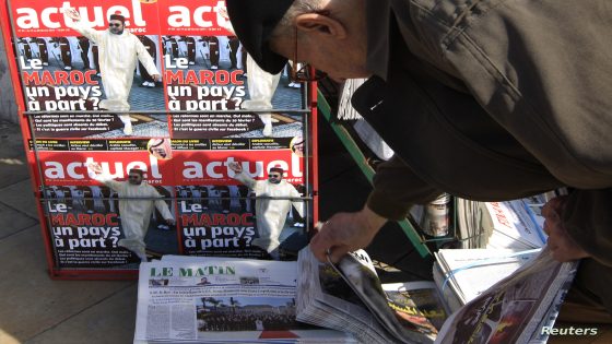 A man selects a daily paper at a news stand near a magazine which shows King Mohammed waving, with the title, "Morocco, a Country which is Different" in Rabat near the Moroccan parliament in Rabat February 22, 2011. Morocco, an ally of the West with a reformist monarch and growing economy is seen by some experts as less susceptible than its neighbours to the unrest buffeting the Arab world. REUTERS/Pascal Rossignol (MOROCCO - Tags: POLITICS MEDIA)