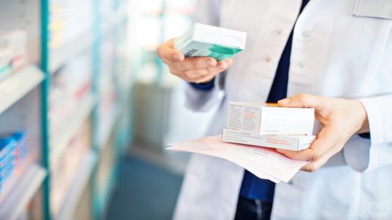 Closeup of pharmacist's hands taking medicines from shelf at the pharmacy