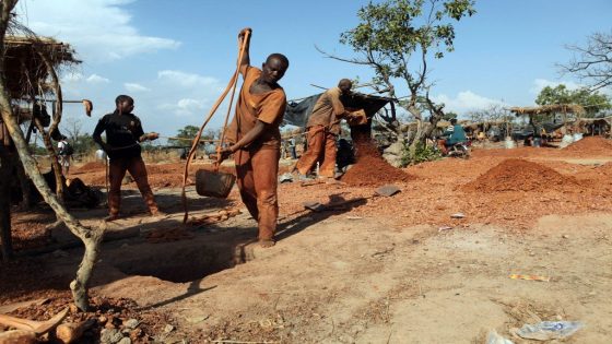 Gold miners empty buckets of earth dug up from underground tunnels in Koflatie, Mali, on October 28, 2014, a mine located a few miles from the border with its southwestern neighbour Guinea. Practiced for centuries, traditional gold panning has in recent years increased following the 2012 Tuareg rebellion, attracting many unemployed Malians to take to gold prospecting in the west of the country. Despite living conditions and hard labor, women and men are trying their luck in the Koflatie. AFP PHOTO / SEBASTIEN RIEUSSEC (Photo by Sebastien RIEUSSEC / AFP)