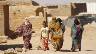 Indigenous Sahrawi women walk through Al Smara desert refugee camp in Tindouf, southern Algeria March 4, 2016. In refugee camps near the town of Tindouf in arid southern Algeria, conditions are hard for indigenous Sahrawi residents. Residents use car batteries for electricity at night and depend on humanitarian aid to get by. The five camps near Tindouf are home to an estimated 165,000 Sahrawi refugees from the disputed region of Western Sahara, according to the United Nations refugee agency UNHCR. REUTERS/Zohra Bensemra SEARCH "THE WIDER IMAGE" FOR ALL STORIES Matching text ALGERIA-SAHARA/ - RTS9CD3