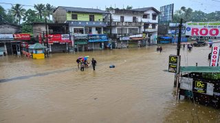 People wade through a flooded road after heavy rainfall in Kaduwela on the outskirts of Colombo on November 28, 2025. Sri Lanka deployed the military for relief and rescue operations on November 28 as the death toll from floods and landslides across the island rose to 56, with another 21 people missing. (Photo by Ishara S. KODIKARA / AFP)