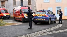 A French Gendarme gestures as fire-fighters trucks drive by in Saint-Just, central France on December 23, 2020, after three gendarmes were killed and a fourth wounded by a gunman they confronted in response to a domestic violence call. - The suspect, a 48-year-old man known to authorities for child custody disputes, was "discovered dead" several hours after fleeing the home in an isolated hamlet near Saint-Just, a village south of the city of Clermont-Ferrand, Interior Minister Gerald Darmanin said in a tweet. (Photo by OLIVIER CHASSIGNOLE / AFP)